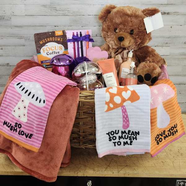 Gift basket with a teddy bear, coffee, skincare items, and mushroom-themed towels