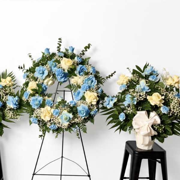Blue and cream floral wreaths and arrangements on stands and stools