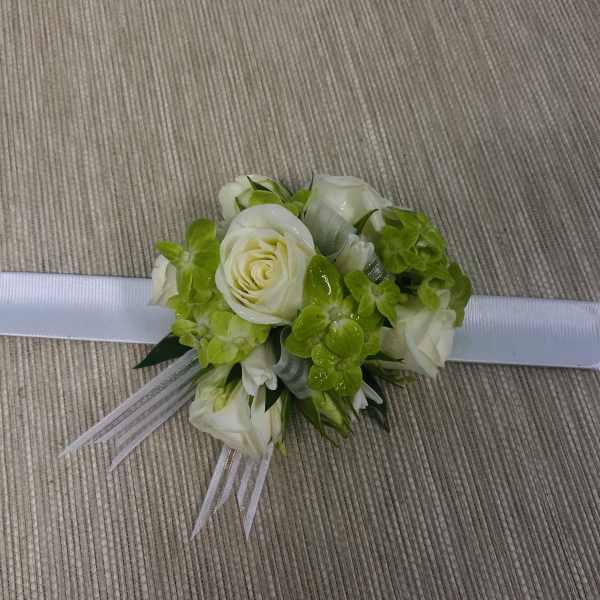White rose wrist corsage with bright green flowers and ribbon ties