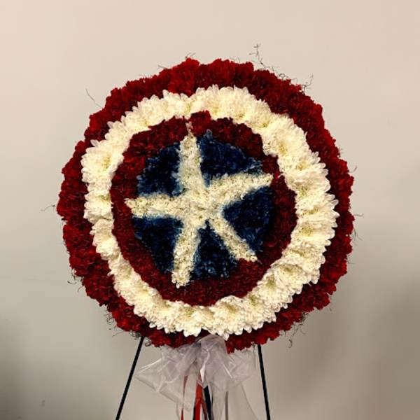 Round floral wreath in red, white, and blue on a stand