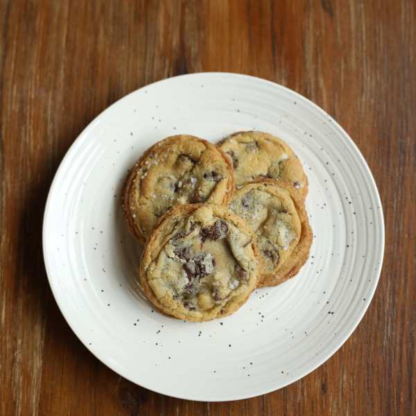 Three chocolate chip cookies on a white plate