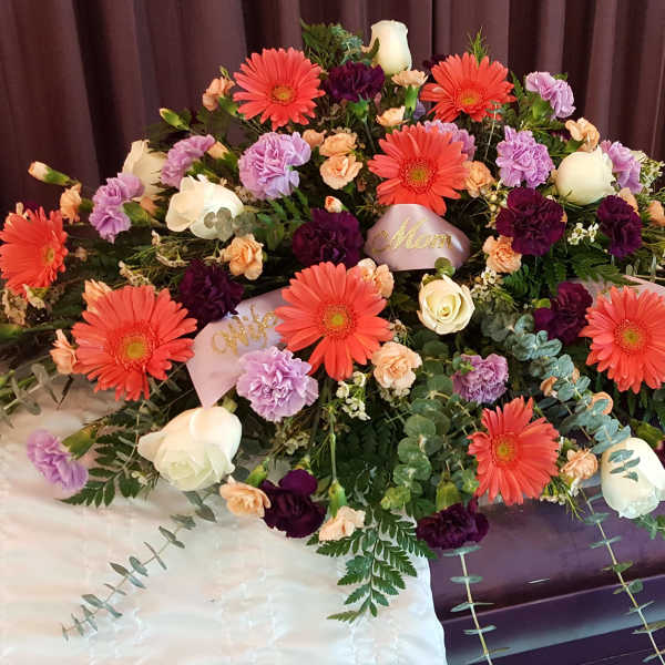 Large casket spray with gerbera daisies, roses, and carnations