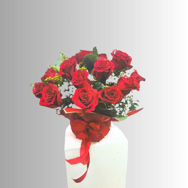 Bouquet of red roses with a red ribbon in a white vase