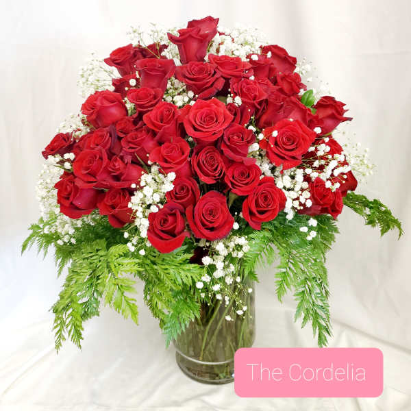 Red roses arranged in a glass vase with white baby's breath