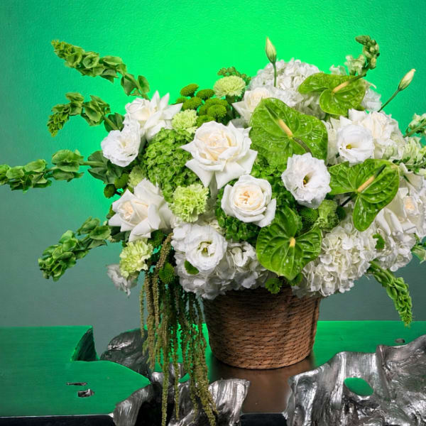 White and green floral arrangement in a woven basket