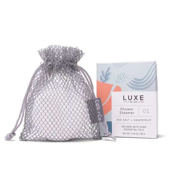 Mesh drawstring bag with a boxed shower steamer