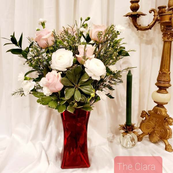 Pink and white roses in a red glass vase
