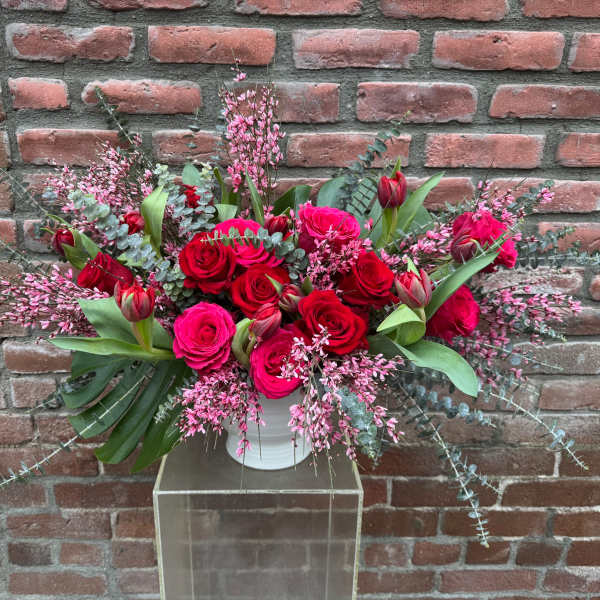 Pink and red rose arrangement in a white vase