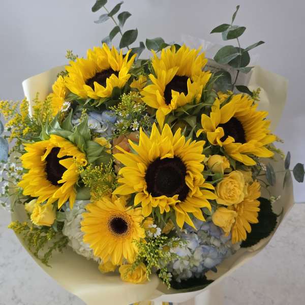 Bouquet of sunflowers with yellow roses and blue hydrangeas