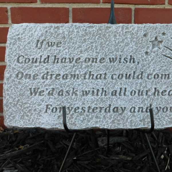 Decorative stone plaque with an engraved wish quote and shooting stars
