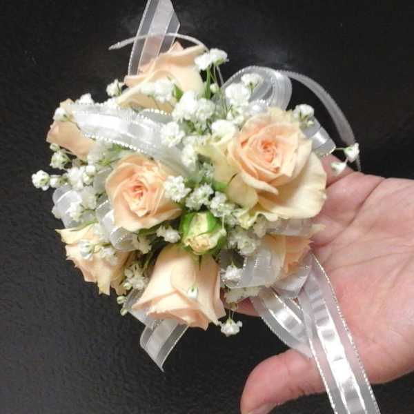 Small peach rose corsage with white ribbon and baby's breath