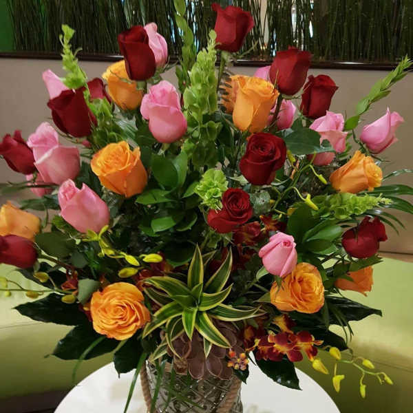 Mixed rose arrangement in a decorative glass vase