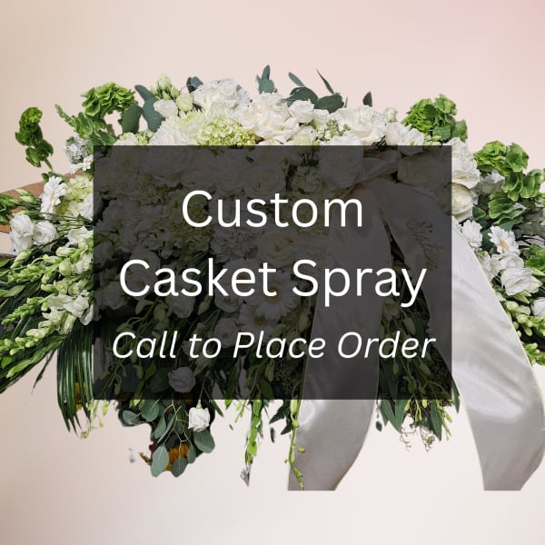White casket spray with ribbon and mixed greenery