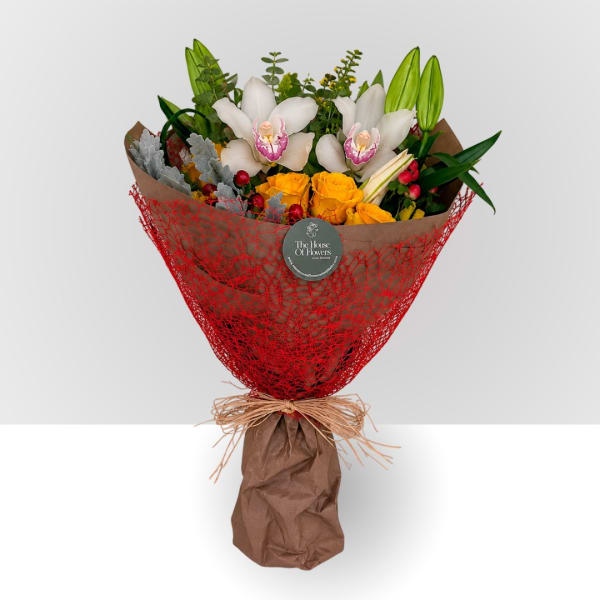 Bouquet of white orchids and yellow roses wrapped in red mesh and brown paper