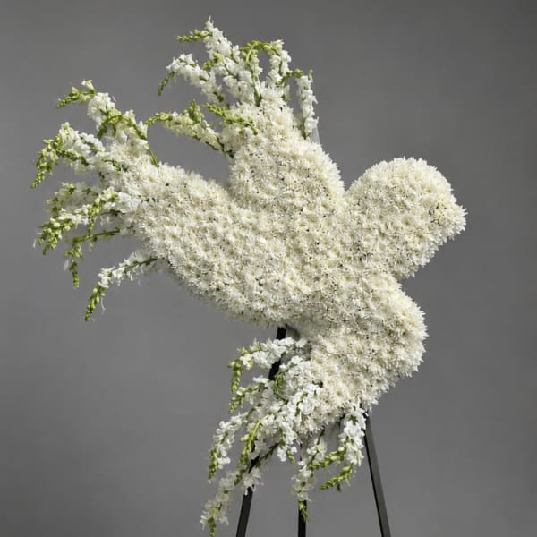 White floral standing spray on a black easel