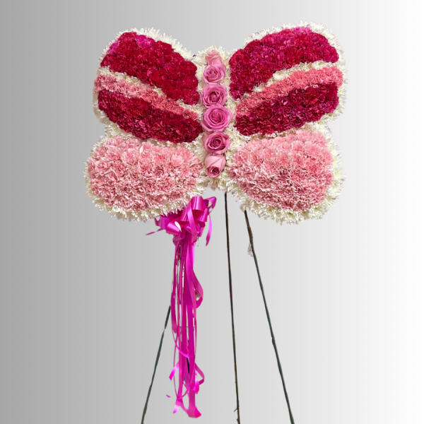 Butterfly-shaped floral arrangement in pink and white with ribbon tails