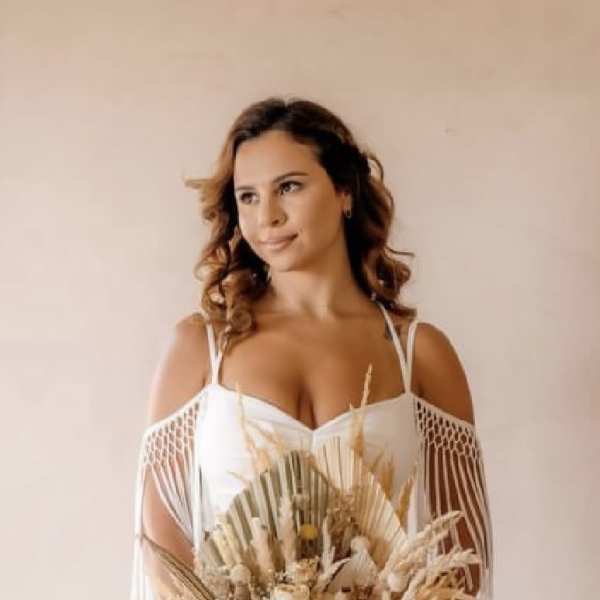 Woman in a white dress holding a dried flower bouquet