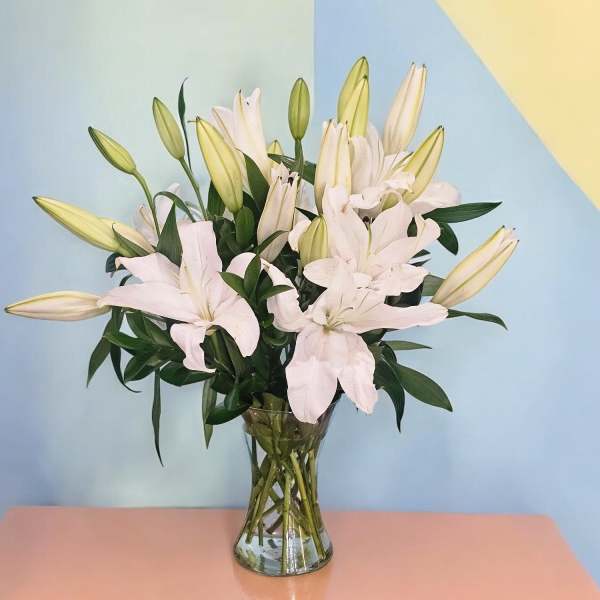White lilies arranged in a clear glass vase