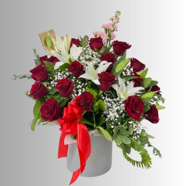 Bouquet of red roses and white lilies in a gray hat box with a red ribbon