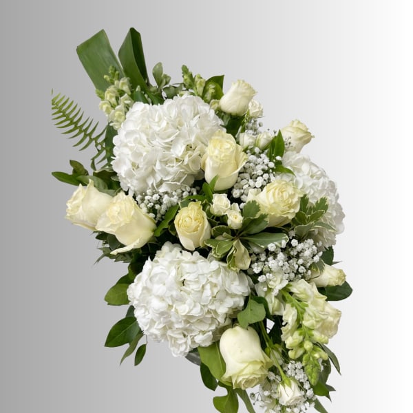 White roses and hydrangeas arranged with greenery in a bouquet