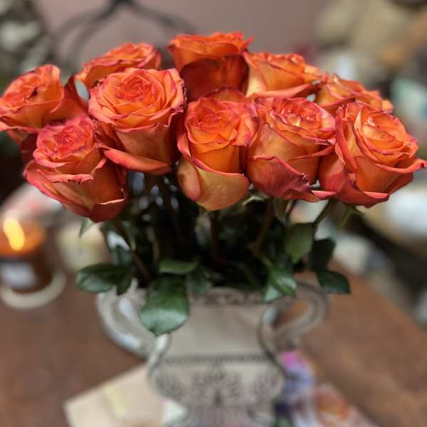 Orange roses arranged in a decorative vase