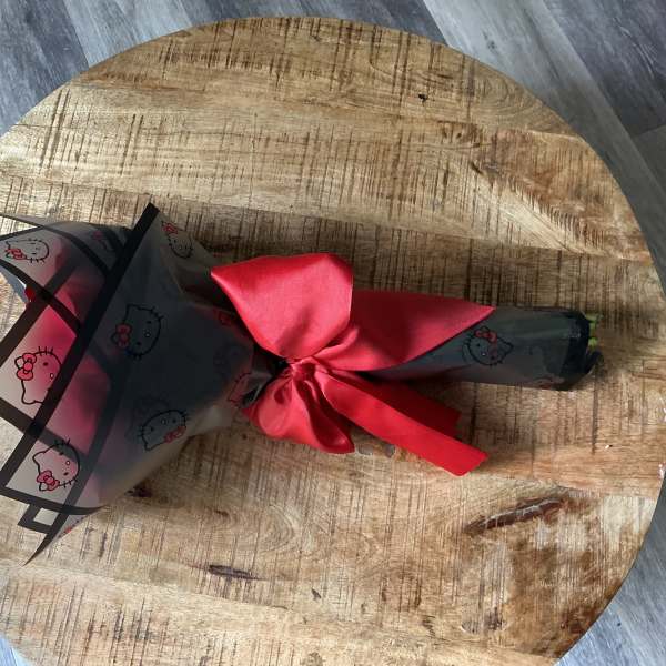 Wrapped bouquet tied with a red satin ribbon