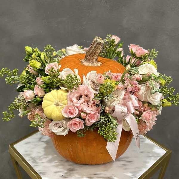 Floral arrangement in a pumpkin with pink and white blooms
