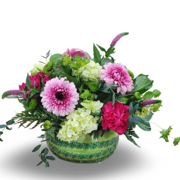Pink and green mixed flower arrangement in a round green vase