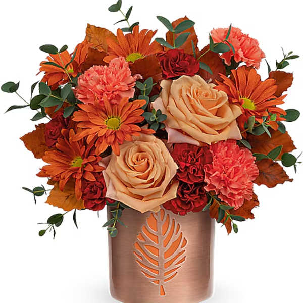 Orange and peach bouquet in a copper vase with leaf cutout