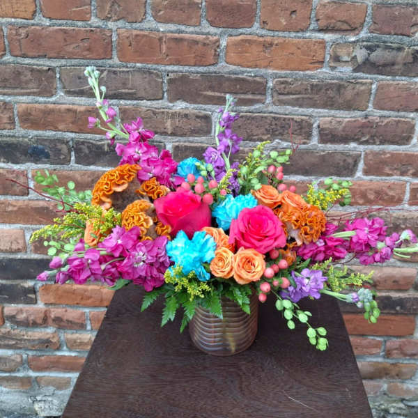 Colorful mixed flower arrangement in a ribbed glass vase