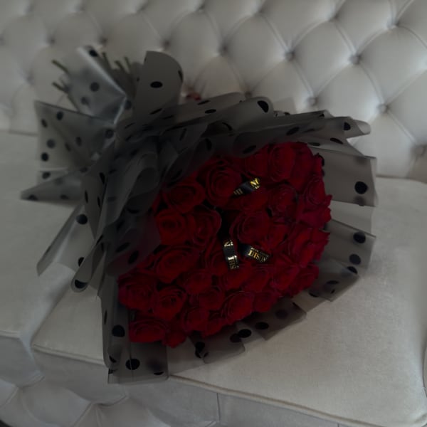 Bouquet of red roses wrapped in black polka-dot paper