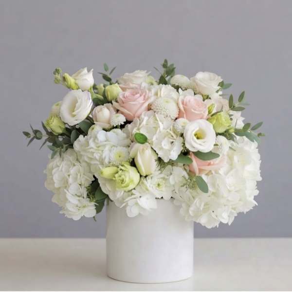 White and blush bouquet in a white cylindrical vase