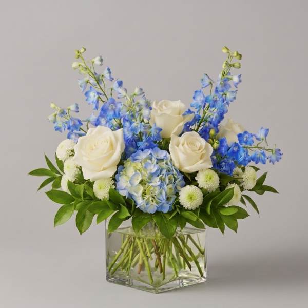 Blue and white flower arrangement in a clear glass vase
