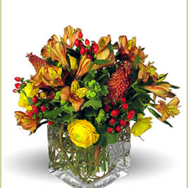 Autumn bouquet in a clear square vase with yellow and orange flowers