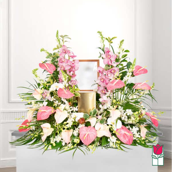 Pink and white floral arrangement with orchids and anthuriums in a gold container