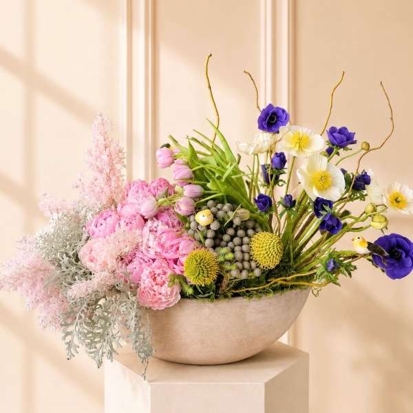 Pink and purple mixed flower arrangement in a shallow bowl vase
