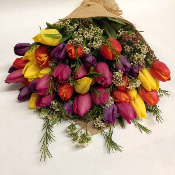 Bouquet of multicolored tulips wrapped in burlap