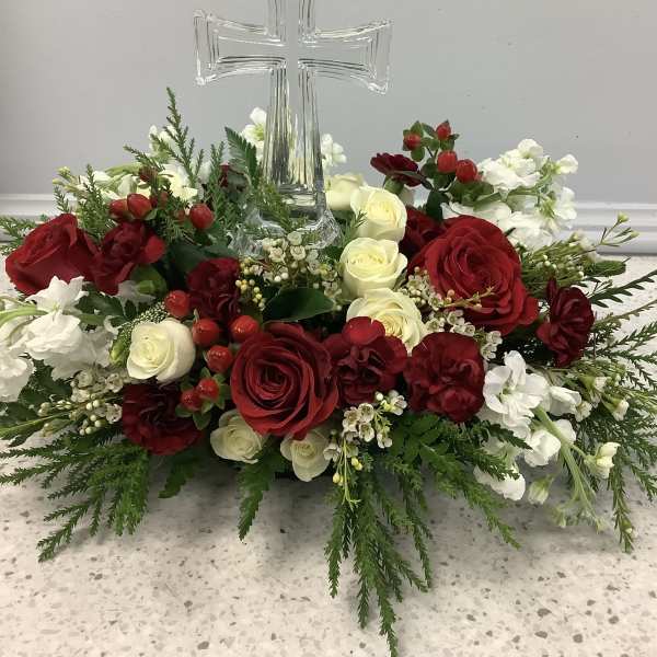 Red and white rose arrangement with a clear glass cross