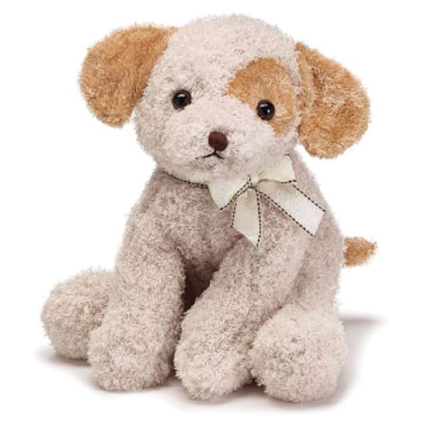 Small plush puppy dog with cream fur, brown ears, and a bow around its neck