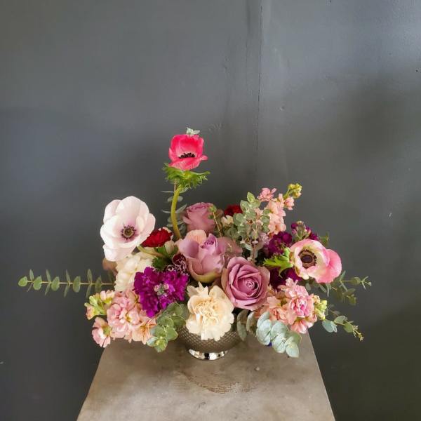Mixed pink and purple flower arrangement in a silver vase