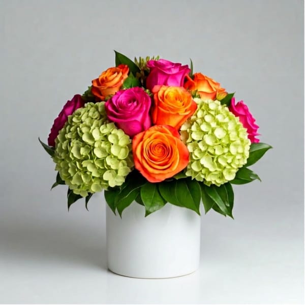Bright roses and hydrangeas arranged in a white vase