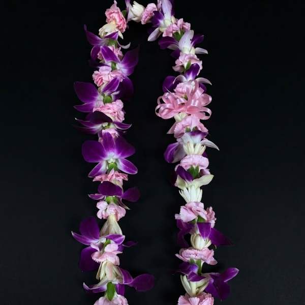 Purple and pink flower lei on a black background