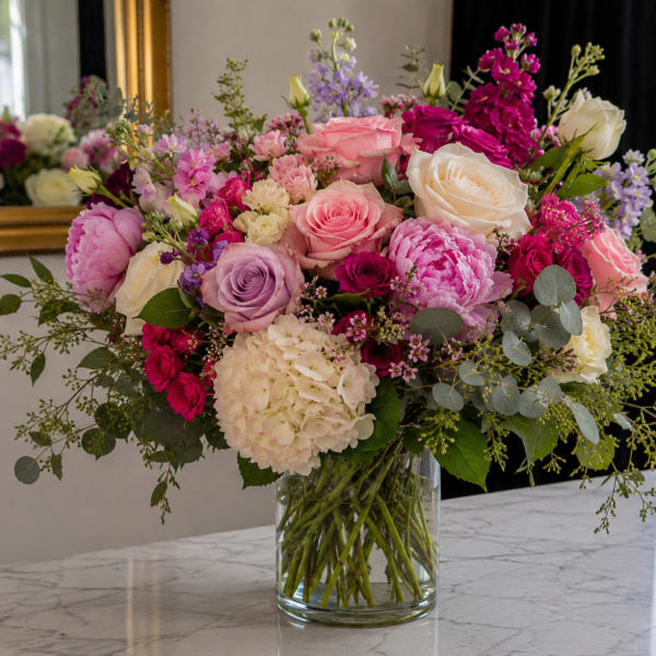 Mixed pink and white flower arrangement in a clear glass vase