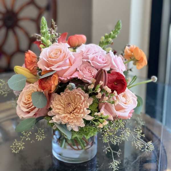Pink and peach flower arrangement in a clear glass vase