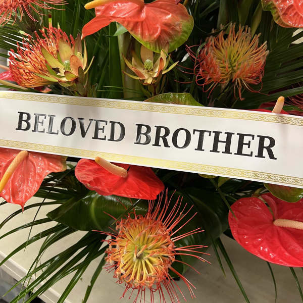Tropical floral tribute with a "Beloved Brother" ribbon