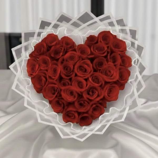Heart-shaped bouquet of red roses wrapped in white paper