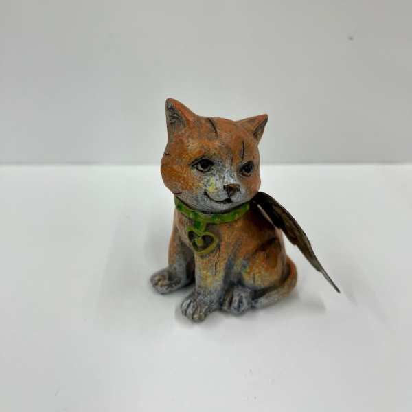 Small painted cat figurine with a green collar and feather wing