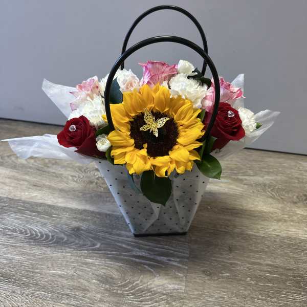 Sunflower and rose arrangement in a handled gift bag
