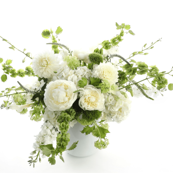 White and green floral arrangement in a white vase