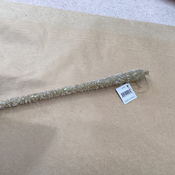 Beaded decorative garland on brown paper with a product tag